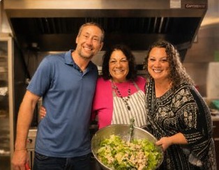 Church members sharing a laugh in the FCC kitchen while preparing a fellowship meal