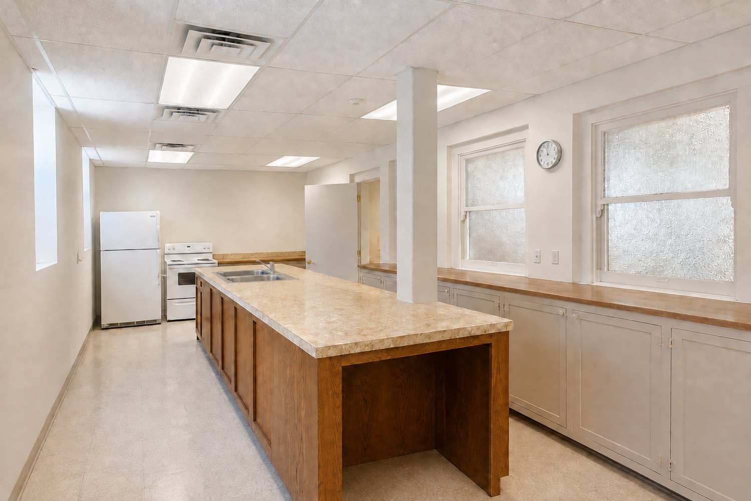 Church kitchen with a wood prep island, sink, refrigerator, range, and built-in cabinets