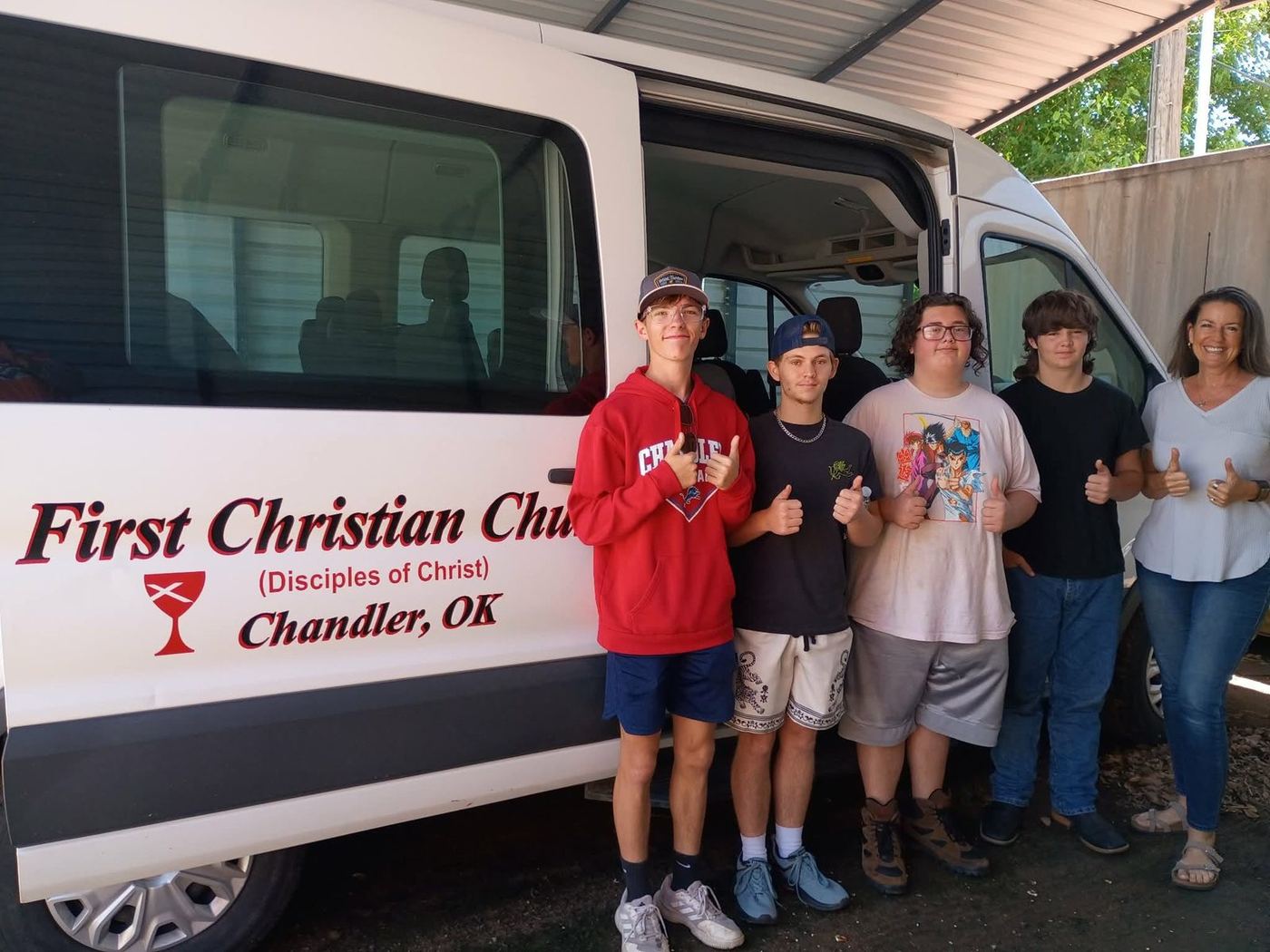FCC youth and leaders standing beside the First Christian Church van