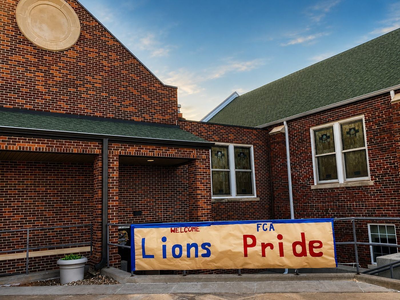 Lions Pride FCA banner outside a brick school building in Chandler, Oklahoma