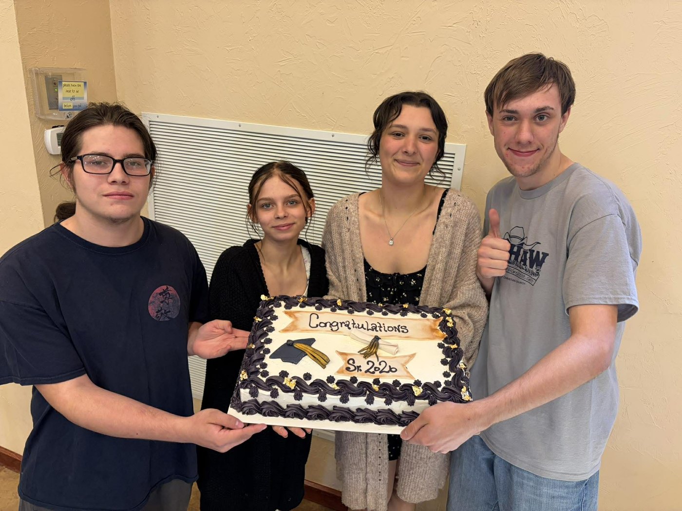 FCC students holding a Congratulations Seniors cake